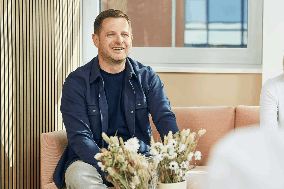 Mann sitzt auf Sofa und lacht