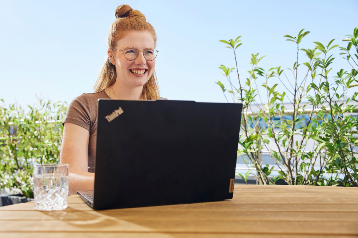 anaptis Mitarbeiterin mit Laptop auf Dachterasse